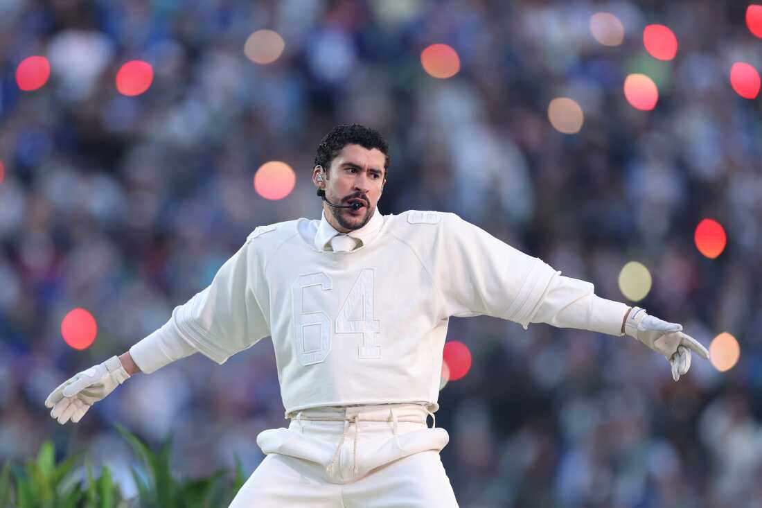 Bad Bunny performing at Super Bowl LX halftime show, 2026, in all-white football uniform with arms outstretched