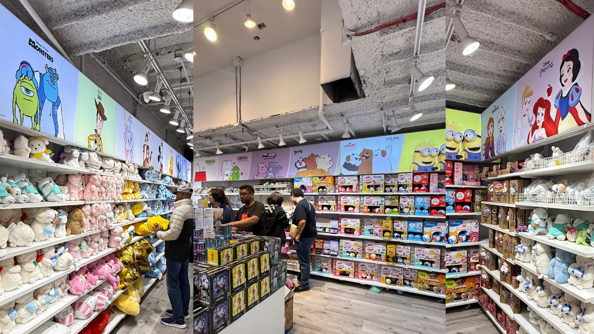 Interior of the Miniso store at 5 Times Square, New York. Disney Pixar Monsters, Care Bears, We Bare Bears, Peanuts, Disney Princess, Stitch, and Hello Kitty character walls surround the customer floor. The Miniso wordmark is not visible above the registers.